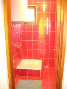 Baño de azulejos rojos con lavabo y espejo en Motel Sretno Good Luck, en Trnovo