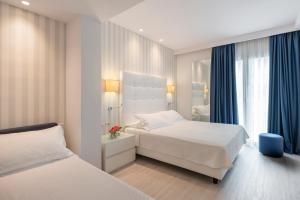A bed or beds in a room at Hotel Fedora Riccione