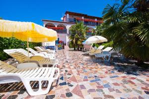 a row of chairs and umbrellas on a patio at Apartments Paradis in Rovinj