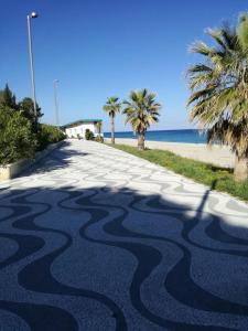 an empty road with palm trees on the beach at Villa Clale in Montauro