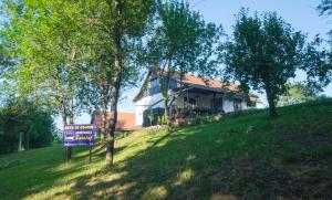 a house on a hill with a sign in front of it at Holiday Home Radočaj in Slunj