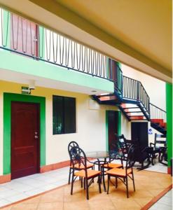 a patio with a table and chairs and a staircase at Hotel Plaza Cosiguina in Chinandega