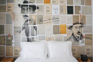 a bedroom with a wall covered in posters at Sapientia Boutique Hotel in Coimbra