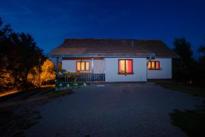 a white house at night with lights on at Holiday Home Radočaj in Slunj