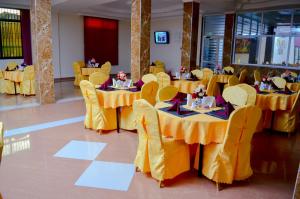 a banquet hall with yellow tables and yellow chairs at Silver Paradise Hotel in Dar es Salaam