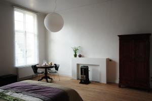 um quarto com uma cama, uma mesa e uma lareira em B&B Alice & Anaïs em Bruges