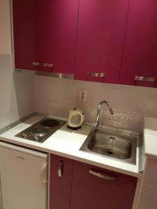 a small kitchen with a sink and purple cabinets at House Villa Roza in Tučepi +90 photos
