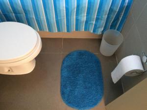a bathroom with a blue rug next to a toilet at Condominio Laguna del Mar in La Serena +20 photos