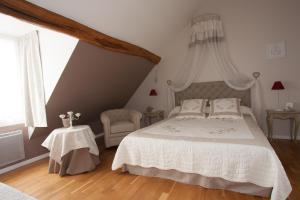 una camera con un letto bianco e una sedia di Les Jarrieres a Dame-Marie-les-Bois