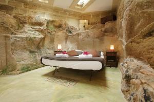 a bedroom with a bed in a rock wall at Villa Punta San Nicola in Favignana