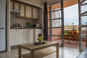 uma cozinha e sala de estar com uma mesa e um fogão em Apartmentos Orlando Costa Adeje em Adeje