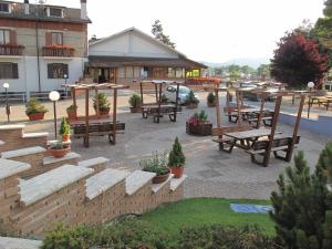 a patio with benches and tables in front of a building at Hotel Ristorante La Nuova Fattoria in Carsoli