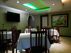 a dining room with two tables and a green ceiling at Hisca Hotel in Duitama