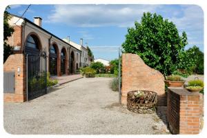 ein Backsteingebäude mit einem Tor neben einer Straße in der Unterkunft Corte delle Giuggiole in Cologna Veneta