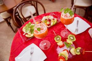 a red table with two glasses of fruit and appetizers at Garibaldi Relais in Sciacca