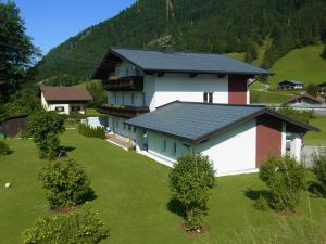 a large white building with a black roof at Gästehaus Walpurga in Russbach am Pass Gschütt