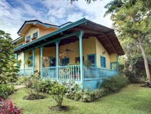 a yellow house with a porch with a balcony at Casa De Las Tias in San José