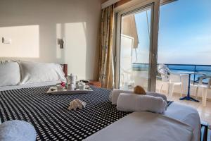 a bedroom with a bed with a view of the ocean at Faros Apartments in Mytikas