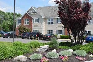 un edificio con coches estacionados en un estacionamiento en Cresthill Suites Syracuse, en East Syracuse