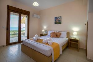 a bedroom with a bed with a view of the ocean at Aphrodite Villas in Kinira