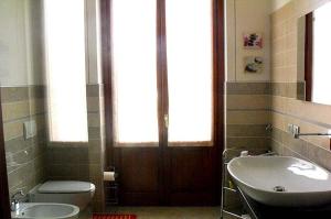 uma casa de banho com um WC, um lavatório e uma porta em il coniglio sulla luna em Erba
