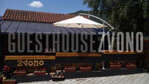 a building with an umbrella in front of a store at Guesthouse Zvono in Pluzine
