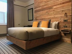 a bedroom with a large bed with a wooden wall at The Southern Belle in Brighton & Hove