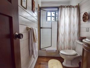 a white bathroom with a toilet and a window at Casa De Las Tias in San José
