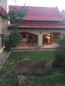 a house with a red roof and a yard at Windsor House in Dullstroom