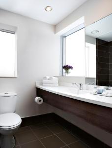 ein Badezimmer mit einem WC, einem Waschbecken und einem Spiegel in der Unterkunft Golden Crown Old City Hotel in Nazareth