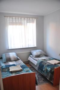 sypialnia z 2 łóżkami i oknem w obiekcie Mieszkanie w Centrum Ustki w Ustce
