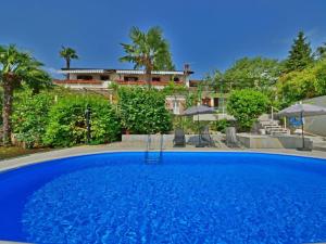 a large blue swimming pool in front of a house at Apartments Piglić in Lovran