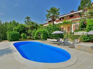 a large blue swimming pool in front of a house at Apartments Piglić in Lovran