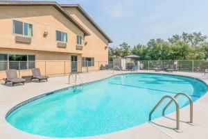 una piscina con sillas y un edificio en Super 8 by Wyndham Redding, en Redding