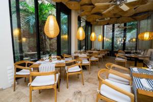 a restaurant with wooden tables and chairs and large windows at Movich Hotel Cartagena de Indias in Cartagena de Indias