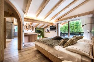 a bedroom with a bed and a large window at Chalet Pineta relax location in Canazei