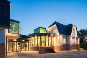 ein großes Gebäude mit einer Treppe davor in der Unterkunft Pura Vida Hotel Cuxhaven in Cuxhaven