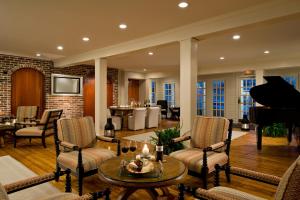 a living room with a piano and a table and chairs at Chatham Wayside Inn in Chatham