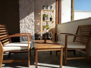 two chairs and a table with wine glasses on a balcony at Albachiara Guest House in Fiumicino