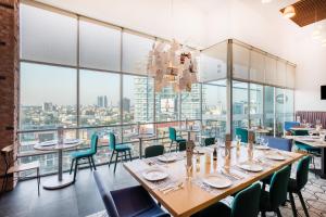 a dining room with tables and chairs and large windows at Tryp WTC Mexico in Mexico City