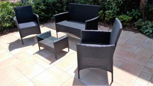 three wicker chairs and a table on a patio at Studio Muenster City in Münster