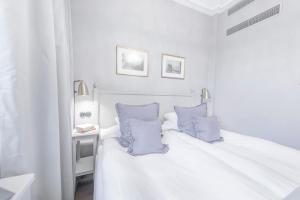 - une chambre blanche avec un lit blanc et des oreillers bleus dans l'établissement Hotel Kungsträdgården, à Stockholm