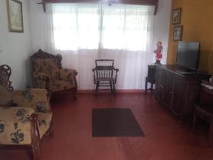 uma sala de estar com televisão e cadeiras e uma janela em La Gaviota BnB em Filandia