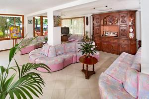 un soggiorno con divani rosa e tavolo di Hotel Corallo a Misano Adriatico