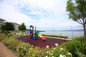 a playground with a slide next to the water at Bamboo Garden & Wellness in Velence