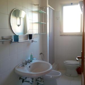 y baño con lavabo, aseo y espejo. en Residenza "Il Geranio", en Badesi