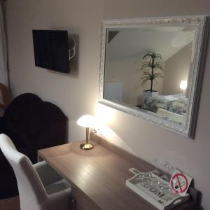lustro na ścianie nad biurkiem z lampką w obiekcie Amberia Mikołajki w mieście Mikołajki