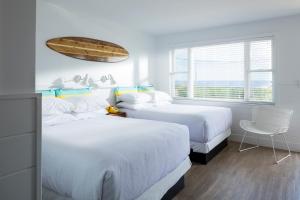 1 dormitorio con 2 camas y ventana en The Shore House, en Narragansett