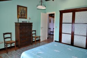 - une chambre avec un lit, une commode et une porte dans l'établissement Appartamento di Villa Ellizabeth, à Milazzo