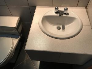 a bathroom with a sink and a toilet at Hostal Bond in Huaraz